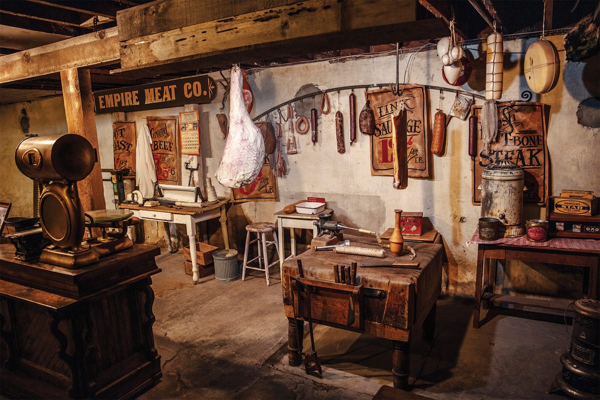 A restored underground butcher shop in Pendleton, Oregon, with an Empire Meat Co. sign, hanging meats, vintage scales and a wooden butcher block