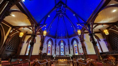 Gothic wooden arches and a deep blue star-painted ceiling inside a historic Nova Scotia church
