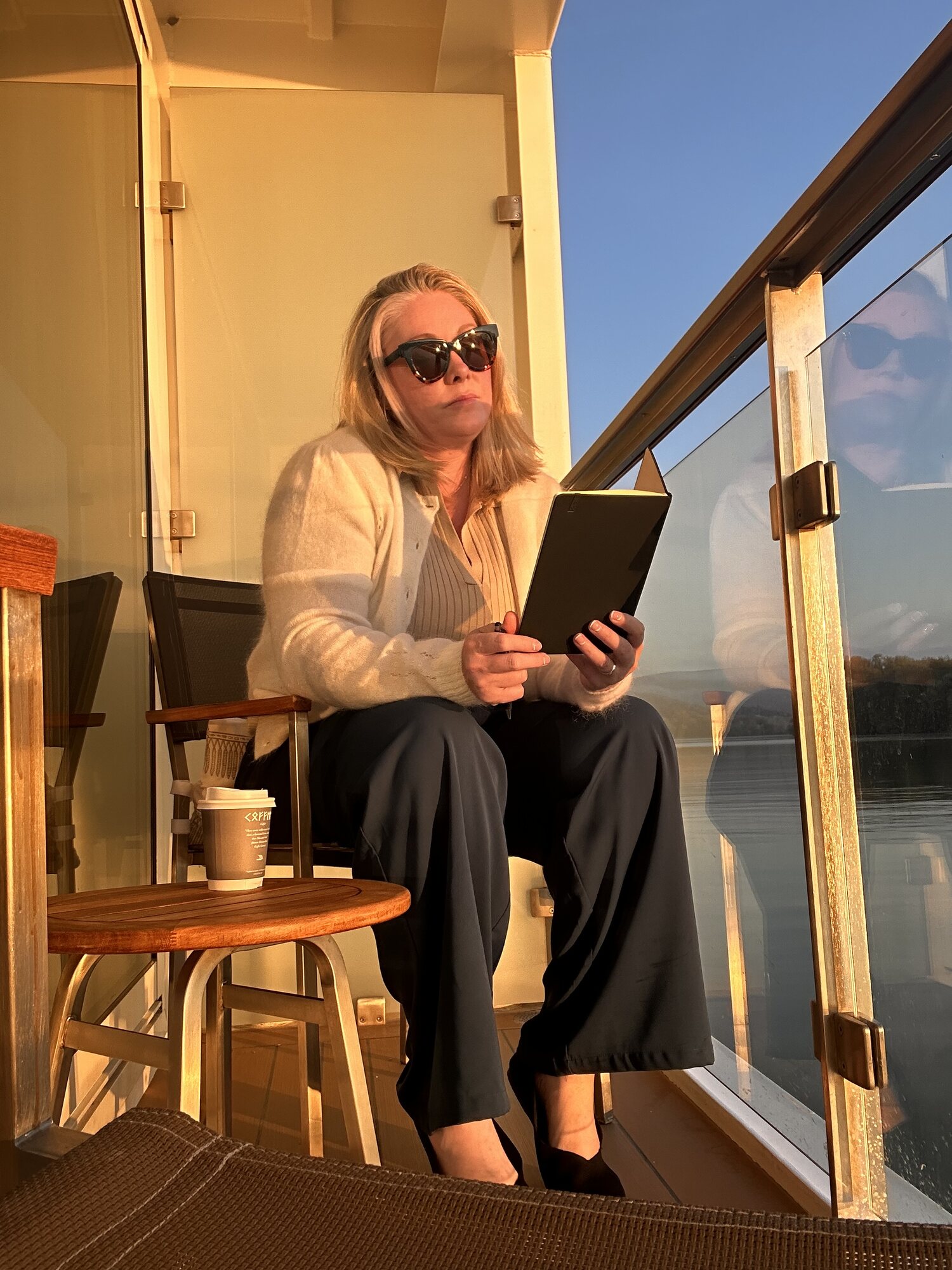 Sarah relaxes on Viking Heimdal's sun deck with a coffee and tablet