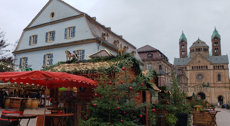 Wooden Christmas Market stalls draped in garland and ornaments in front of Speyer Cathedral in Germany