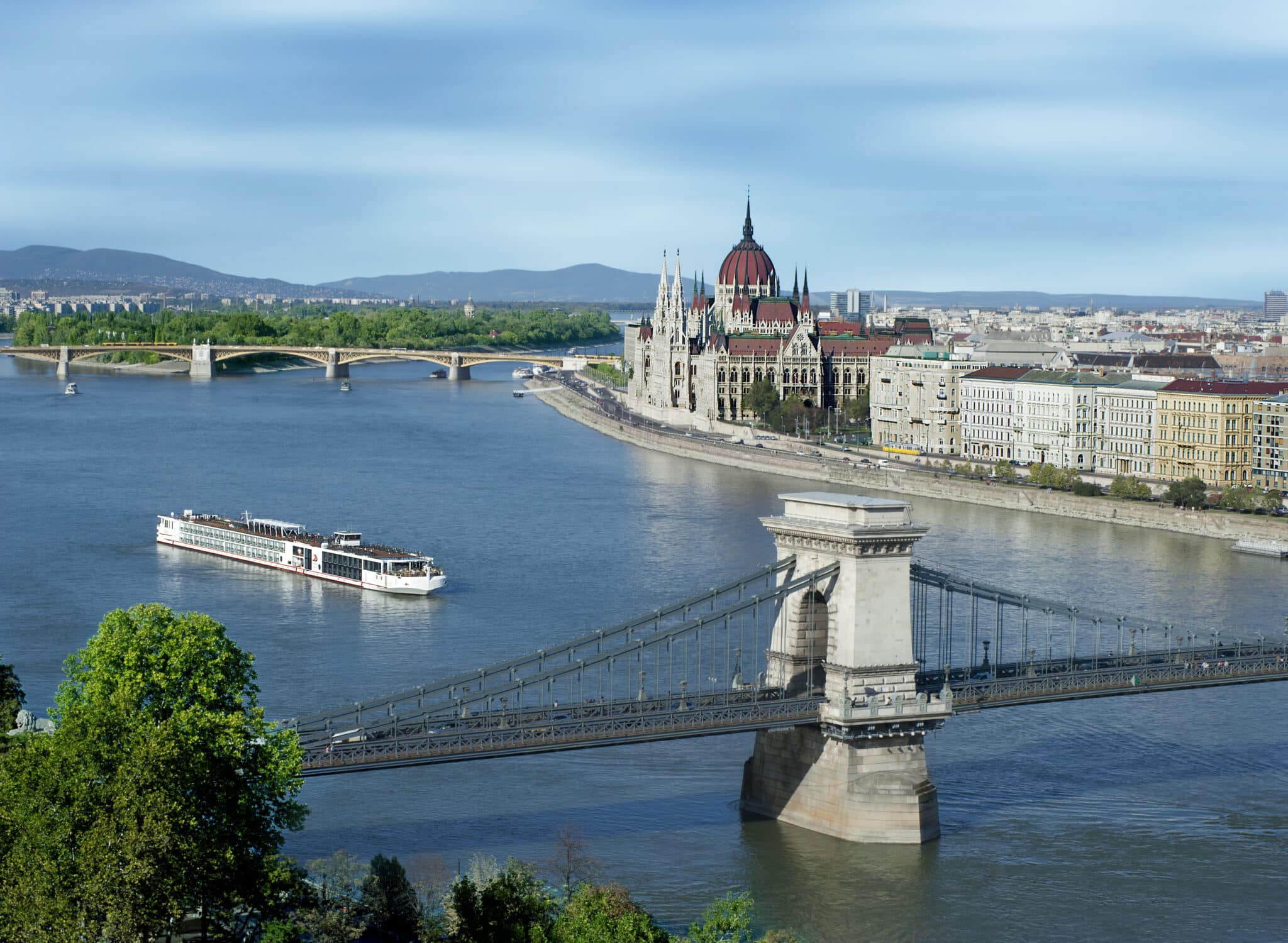 Viking river cruise ship sailing past the Hungarian Parliament Building and Chain Bridge in Budapest