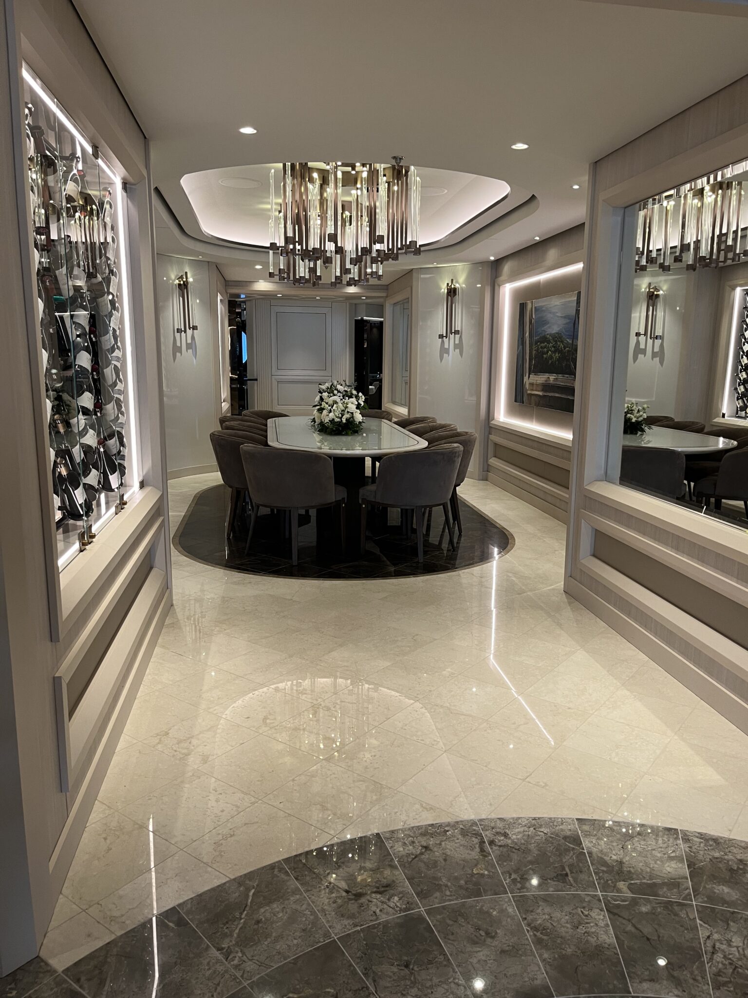 Elegant Chef's Table private dining room with crystal chandelier, illuminated wine walls, and oval table setting